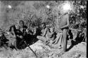 /Twikwe, Tsekue, N!whakwe, and two others watching the gemsbok butchering