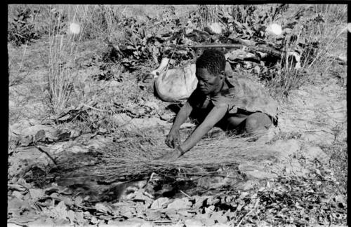 Oukwane laying grass over a hole