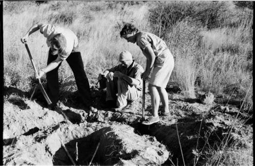 Elizabeth Marshall Thomas and John Marshall digging; another expedition member sitting