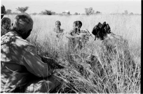 !Gai and Oukwane sitting in the grass with Laurence Marshall and Lorna Marshall