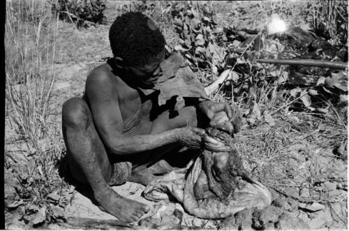 Oukwane holding the gemsbok stomach bag partly filled