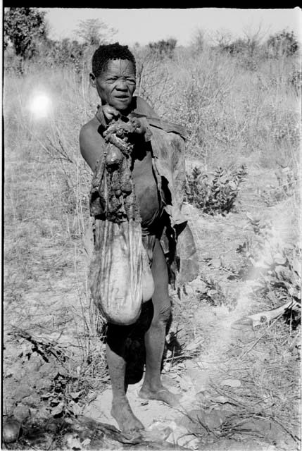 Oukwane standing, holding the gemsbok stomach bag