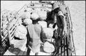 Men standing in a truck bed looking at salt blocks at Bitters Pan