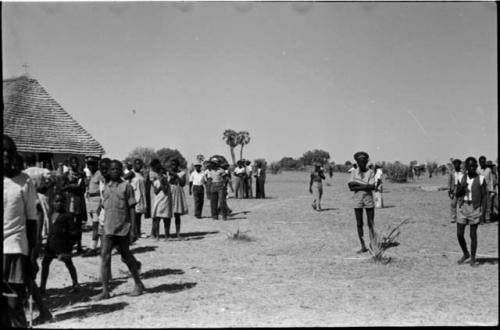 Groups of women and men walking and standing in front of church