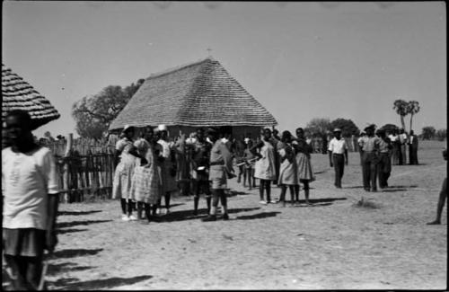 Groups of women and men walking and standing in front of church