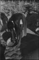 Woman leaning over a basket of grain