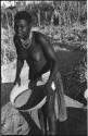 Woman standing and holding a basket of grain