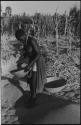 Woman standing and holding a basket of grain