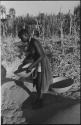 Woman standing and holding a basket of grain