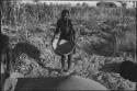 Woman standing and holding a basket of grain