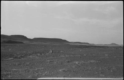 Person sitting, with buttes in background