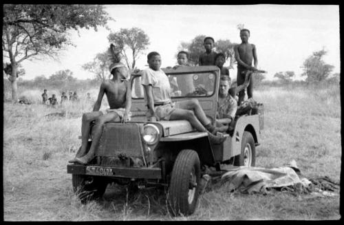 John Marshall and unidentified Ju/'hoansi in a Jeep