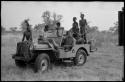 John Marshall and unidentified Ju/'hoansi in a Jeep