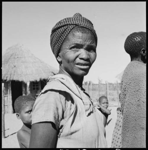 Woman standing, close-up, with children behind her