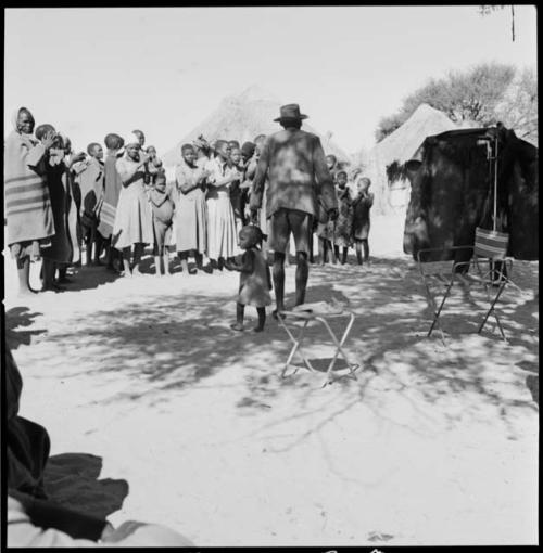 Women clapping and singing, being recorded