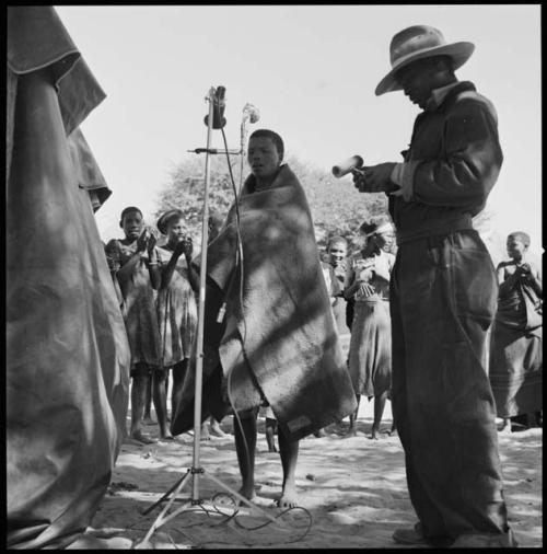 Rose, a soloist, and Kernel Ledimo using microphone, and women standing and clapping