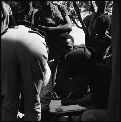 Group of people having their skin color documented, with Deborah Marshall bending over