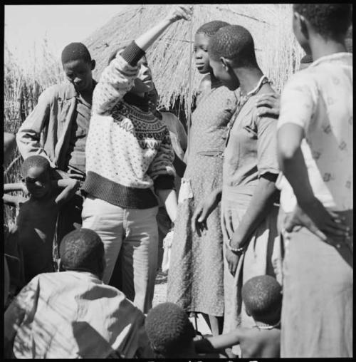 Girl having her height measured by Deborah Marshall, and other people standing next to them