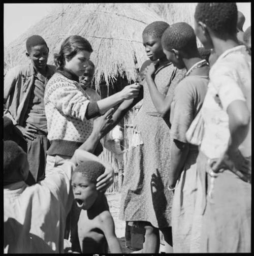 Girl having her height measured by Deborah Marshall, and other people standing next to them