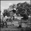 C. J. Mathias, Deborah Marshall and Lorna Marshall reading and writing at camp