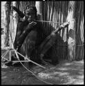 Siamo playing kagoma (musical bow) in front of a microphone, close-up