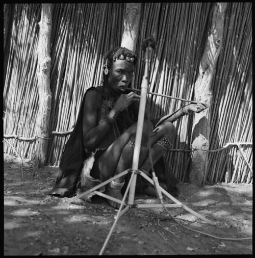 Siamo playing kagoma (musical bow) in front of a microphone, close-up