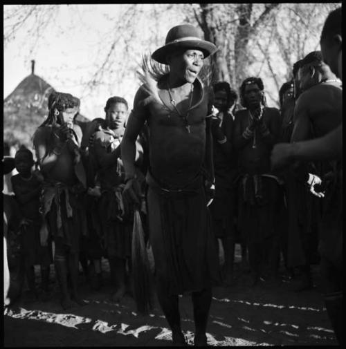 Man dancing, with group of women singing in background