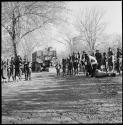 Men playing drums, and group of people singing, with expedition truck in background