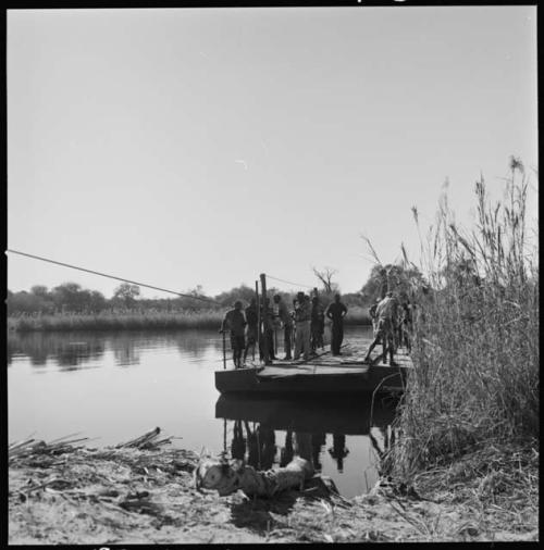 Group of people standing on a float that is crossing the water