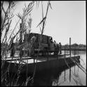 People standing next to Chevrolet on float, coming in to the shore