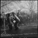 Man and woman dancing near expedition microphone, with group of people singing in background