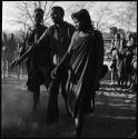 Man and two women dancing, one pair has their arms out to side