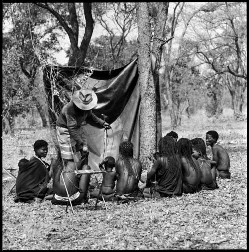 Group of women singing into a microphone, and Kernel Ledimo standing and holding another microphone