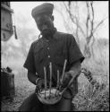 Bela wearing a turban, and playing otshixumba (//guashi)