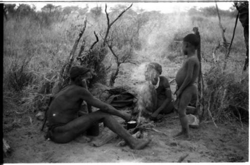 Three-member family in their living place, with the smoke of the fire rising