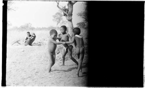 Three boys spinning in a circle (image partly obscured)