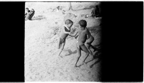 Three boys spinning in a circle (image partly obscured)