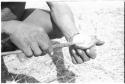 Person's hands holding a bone and a mixing stick