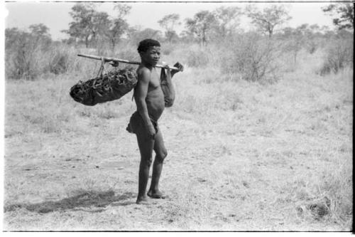 Side view of ≠Toma with a carrying stick