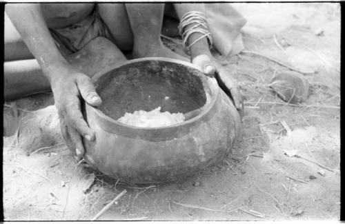 Wooden bowl with food held by a person's hands