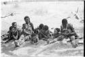 Group of women and children lying and sitting on the ground, including  /Goishay (wife of ≠Gao) on extreme left