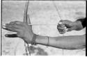 Close-up of "Crooked /Qui's" hands, showing arrow release and position of left hand on bow