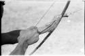 Close-up of "Crooked /Qui's" hands, showing arrow release and position of left hand on bow