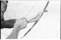 Close-up of "Crooked /Qui's" hands, showing arrow release and position of left hand on bow