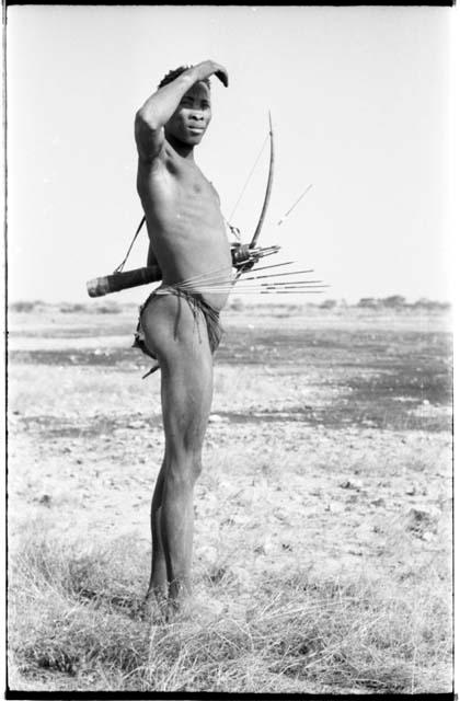 "Crooked /Qui" showing six arrows in place ready to be pulled out of his belt, full figure standing