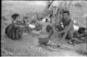 "Gao Music" and his wife, ≠Nisa, sitting at their living place with the iron pot on the fire