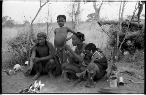 Gao (son of Gau, and brother of /Gasa) sitting with Di!ai and their two children