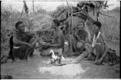 "Old /Gasa" sitting with two of her sons, Gao and ≠Gao, and her daughter, ≠Gisa