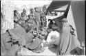 Group of Ju/'hoansi, Kernel Ledimo, Lorna Marshall gathered around to look at beads, seemingly in the cold