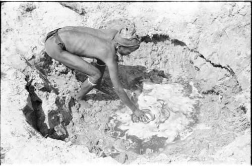 "/Gao Music" dipping ostrich eggshell at a waterhole